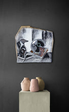 Load image into Gallery viewer, Black Jug and Skull by Scoobafish displayed on a dark interior wall above a plinth with ceramic vessels, illustrating the artwork’s scale.