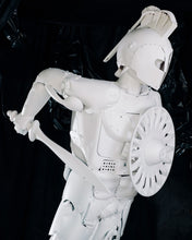Load image into Gallery viewer, Upper-body view of Plastic Apocalypse – Trojan Warrior, showing the white helmet, shield and spear assembled from reclaimed objects.
