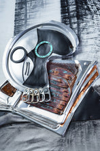 Load image into Gallery viewer, Detailed view of the skull in Black Jug and Skull by Scoobafish, assembled from a metal lid, painted shapes and weathered found objects.
