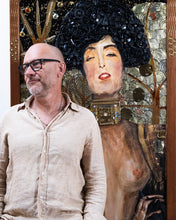 Load image into Gallery viewer, Artist Scoobafish standing beside Judith, showing the scale of the large framed mixed-media artwork.
