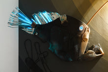Load image into Gallery viewer, Warm illumination detail showing plastic fish sculpture environmental art installation by Maurizio Sergiusti
